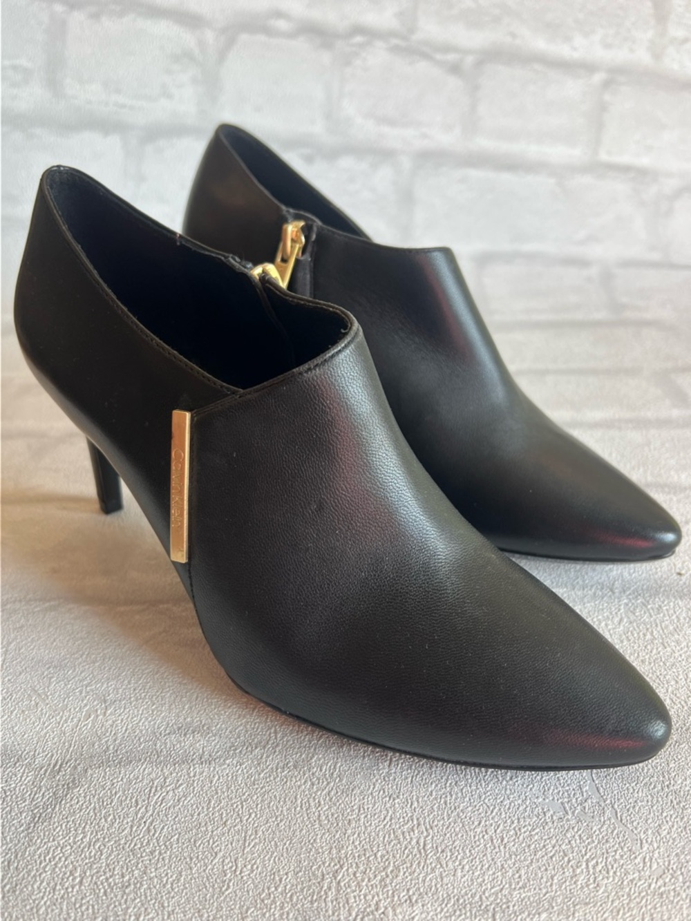Calvin Klein Black Pointed Leather Ankle Booties with Gold Accent